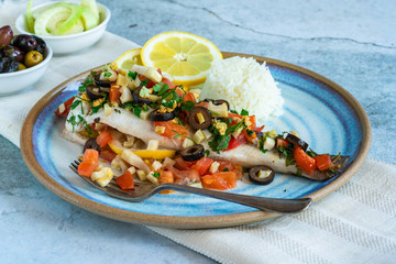 Mediterranean sea bass stuffed with tomatoes, lemons, fennel and olives. Greek cuisine.