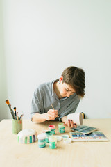 the pottery woman holds in hands a mug to paint the ornament