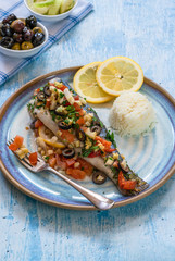 Mediterranean sea bass stuffed with tomatoes, lemons, fennel and olives. Greek cuisine.