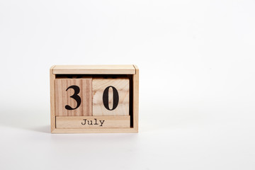 Wooden calendar July 30 on a white background