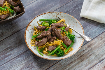 Honey and sesame beef noodles with green vegetables - high angle view