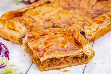 Homemade cabbage pie on wooden rustic background. Close up