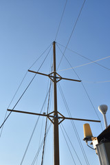 Obraz premium High old mast of the ship against the blue sky on a pleasure boat