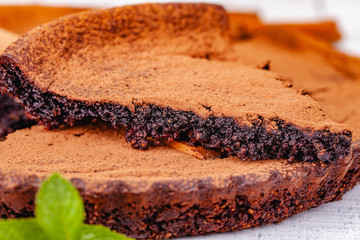 Sliced chocolate pie with cinnamon on wooden rustic table. Close up