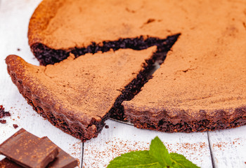 Sliced chocolate pie with cinnamon on wooden rustic table. Close up