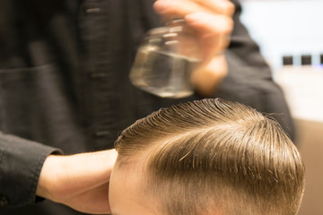 Fototapeta premium Hairdresser cutting hair. Hairdresser at work cutting customers hair