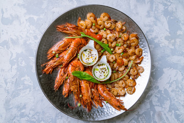 some langoustines on a plate on grey concrete and grilled shrimps