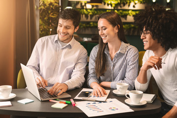 Business colleagues working with presentation together at cafe