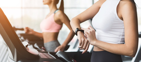 Burning calories. Woman looking at her smart watch at the gym