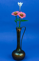 Rain lily (Zephyranthes candida) and zinnia flowers in vintage Arabic Brass Vase