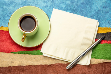 napkin, pen and a cup of coffee