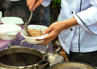 Social workers hand out porridge to poor elderly people.