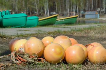 Lake, buoys on the shore in a pile. The concept of preparation for summer holidays.