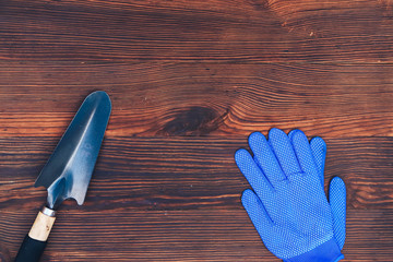 garden tools on a wooden background gloves and shovel