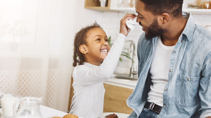 Happy afro man and his daughter having breakfast