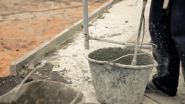 Mixing cement in a old bucket