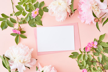 Mockup wedding invitation and envelope with pink peonies on a pink background