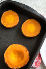 Round pieces of baked pumpkin on baking sheet