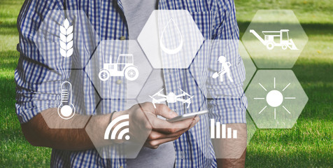 Man farmer with digital tablet in field using apps