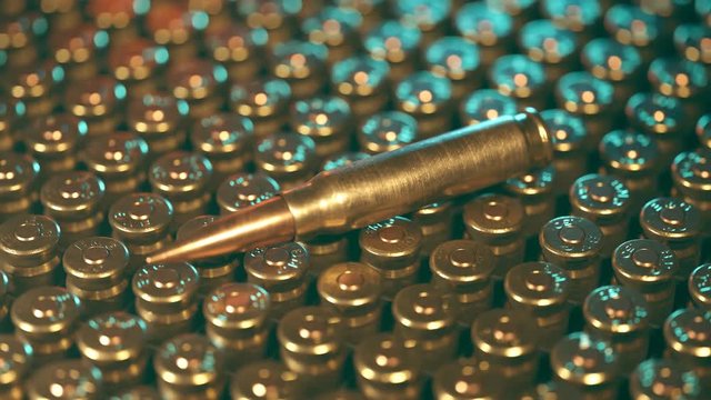 Rows of .50 BMG machine gun ammunition in plastic container.  One bullet on top.