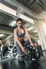 Fototapeta na wymiar Young asian woman lifting barbell in gym. healthy lifestyle and workout motivation concept.