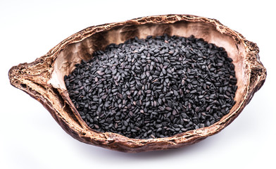Black sesame seeds in the organic bowl on white background. Top view.