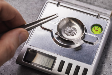 Specialist measures the weight of gems on a jewelry scale. Close-up workflow