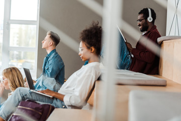 selective focus of multiethnic students with digital devices in lecture hall