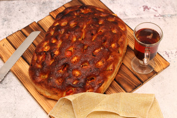 Italian bread with cheese, tomatoes and herbs. Focaccia on the table.