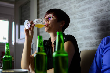 A lonely attractive woman is singing a beer on a failed party.