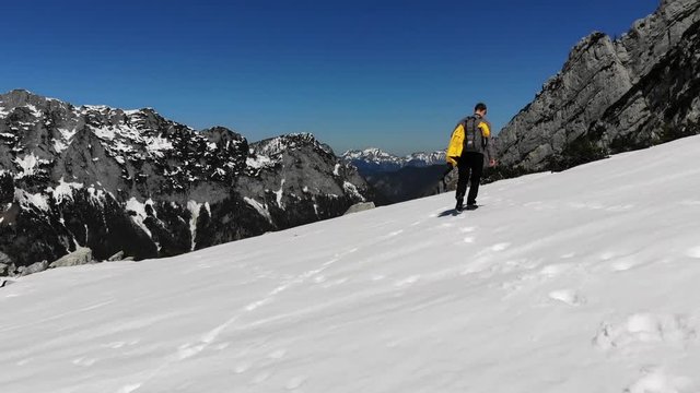 Man is hiking through snowy mountains in the Alps in Berchtesgaden, Bavaria, Germany