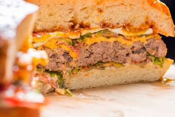  large burger in the cut. Thick layers of cutlet, cheese and vegetables with sauces