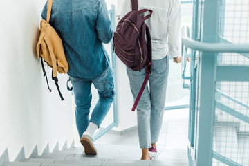 cropped view of two students with backpacks in college