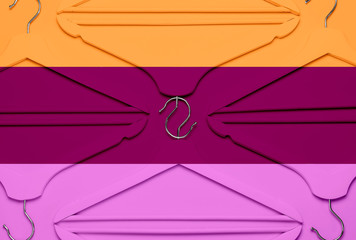 Creative fashion concept. Flat lay top view colored wooden hangers on multi-colored background minimalism style pop-art. Sale discount store shopping concept, design empty hanger feminine blog