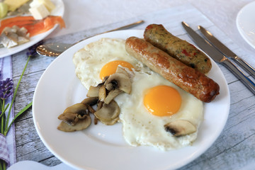 Fried eggs with sausages and mushrooms