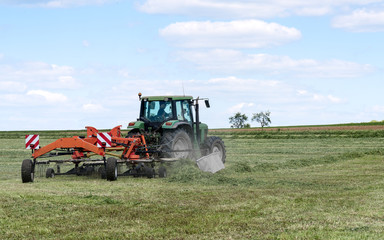 Obraz premium tracteur agricole avec rassembleur de foin en action