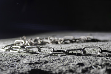 Old rusty chain lying on the ground.