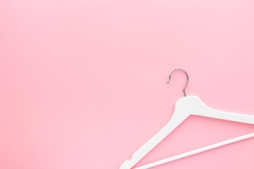White hangers on pastel pink background