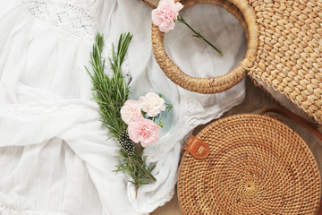 fashionable round straw bag with carnation flowers, top view close-up © tata_cos