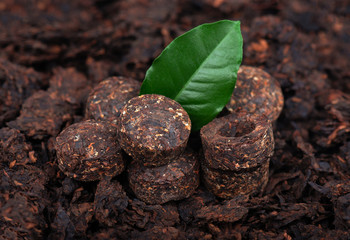Aromatic black pu-erh tea. Fermented and compressed Leaves into bricks. Round flat disc of puer tea. Healthy drink.