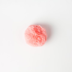 Coral fluffy fur ball on white background