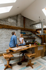 Fototapeta na wymiar Young couple in love eating pizza in the rustic home