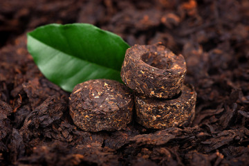 Aromatic black pu-erh tea. Fermented and compressed Leaves into bricks. Round flat disc of puer tea. Healthy drink.