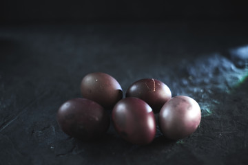 Dark purple eggs on a rough cement background