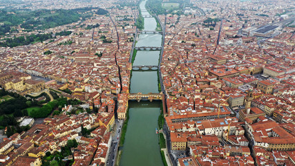 Aerial view of Ponte Vecchio bridge on Arno river in Florence city center, Italy. Italian orange...