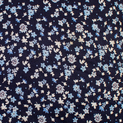 blue small flowers on a dark background on fabric texture fabric