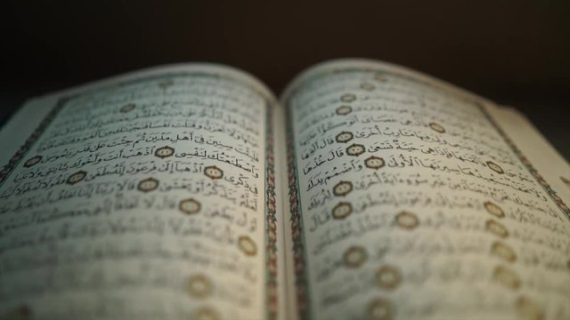 the holy Quran muslim holy book, detail of surah in slow motion 