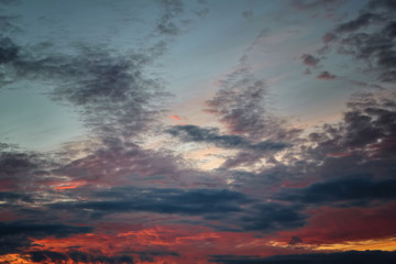 The sky with dark clouds illuminated by the setting sun