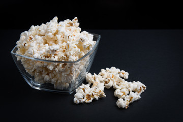 popcorn in a glass bowl on a black background