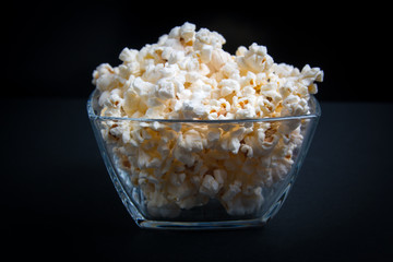 popcorn in a glass bowl on a black background
